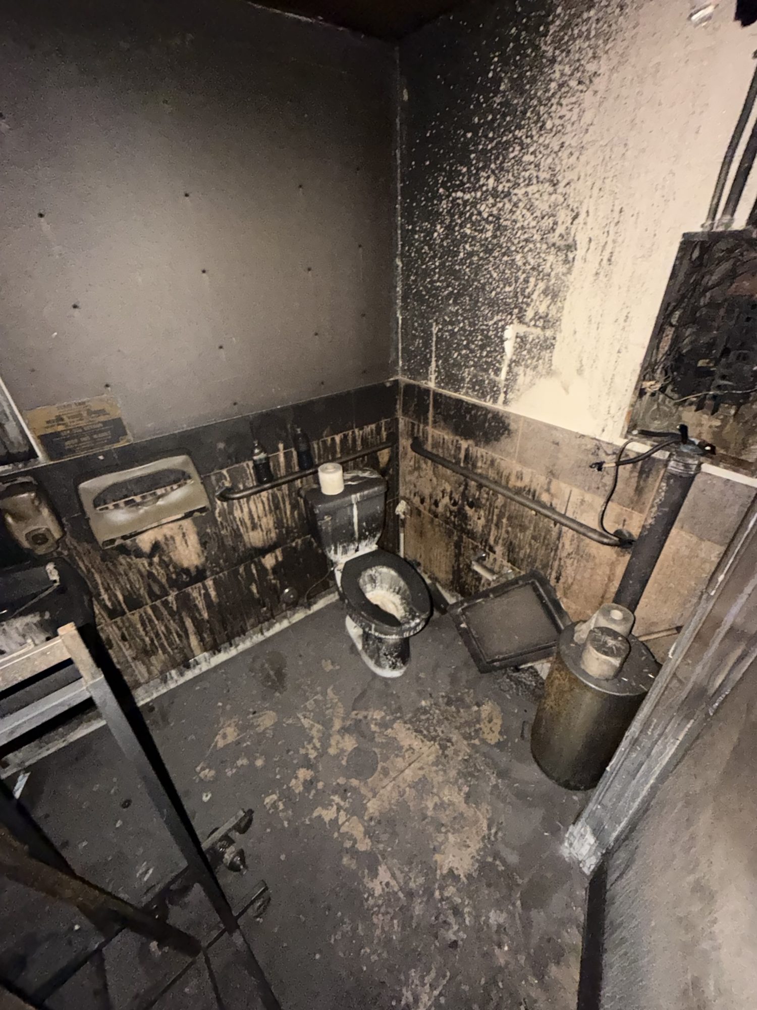 fire-damage-10-restroom-smoke-damage Heavy soot deposition on restroom walls and fixtures after a commercial fire in San Diego