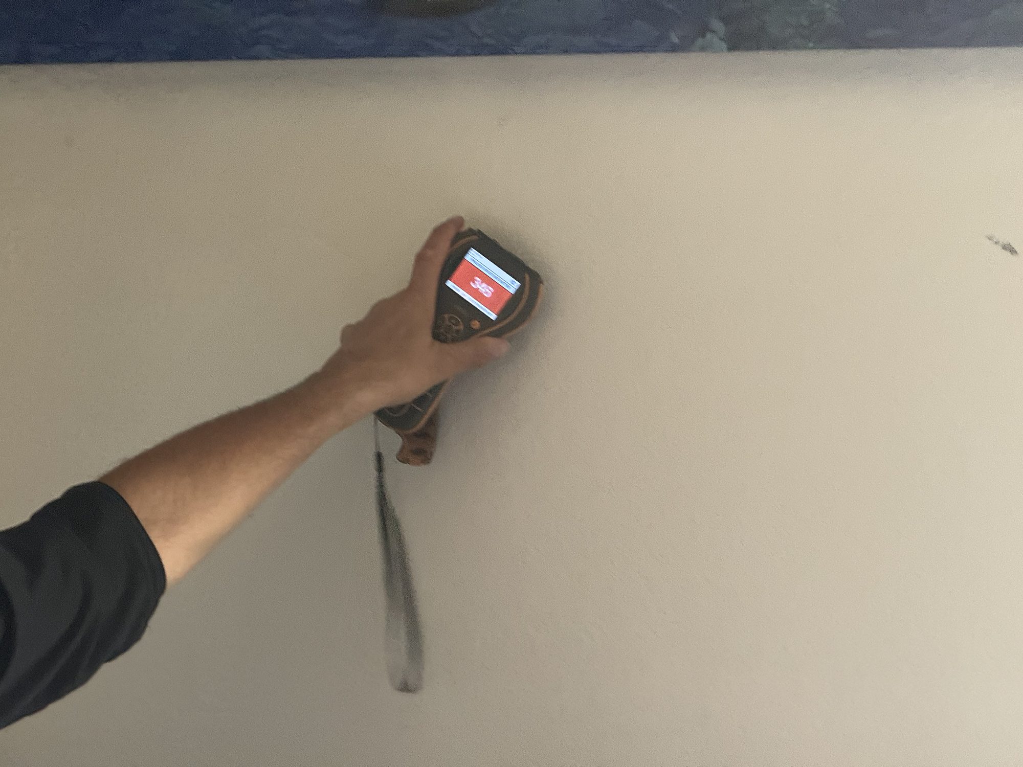 fire2-07-moisture-meter-reading-detail Technician taking a moisture meter reading to locate hidden water inside a wall in a San Diego home