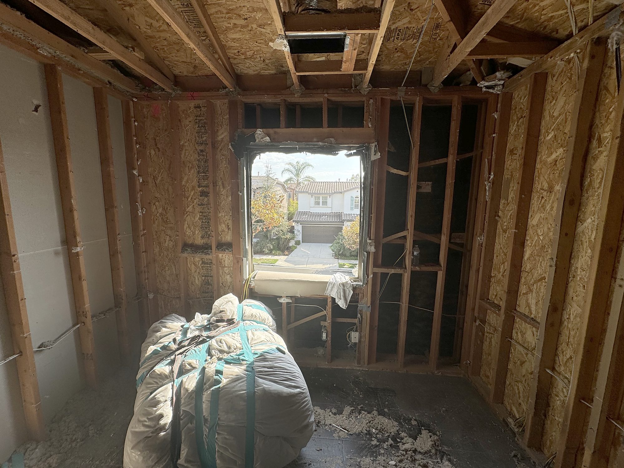 Bedroom taken down to framing and sheathing during reconstruction of a fire-damaged San Diego home