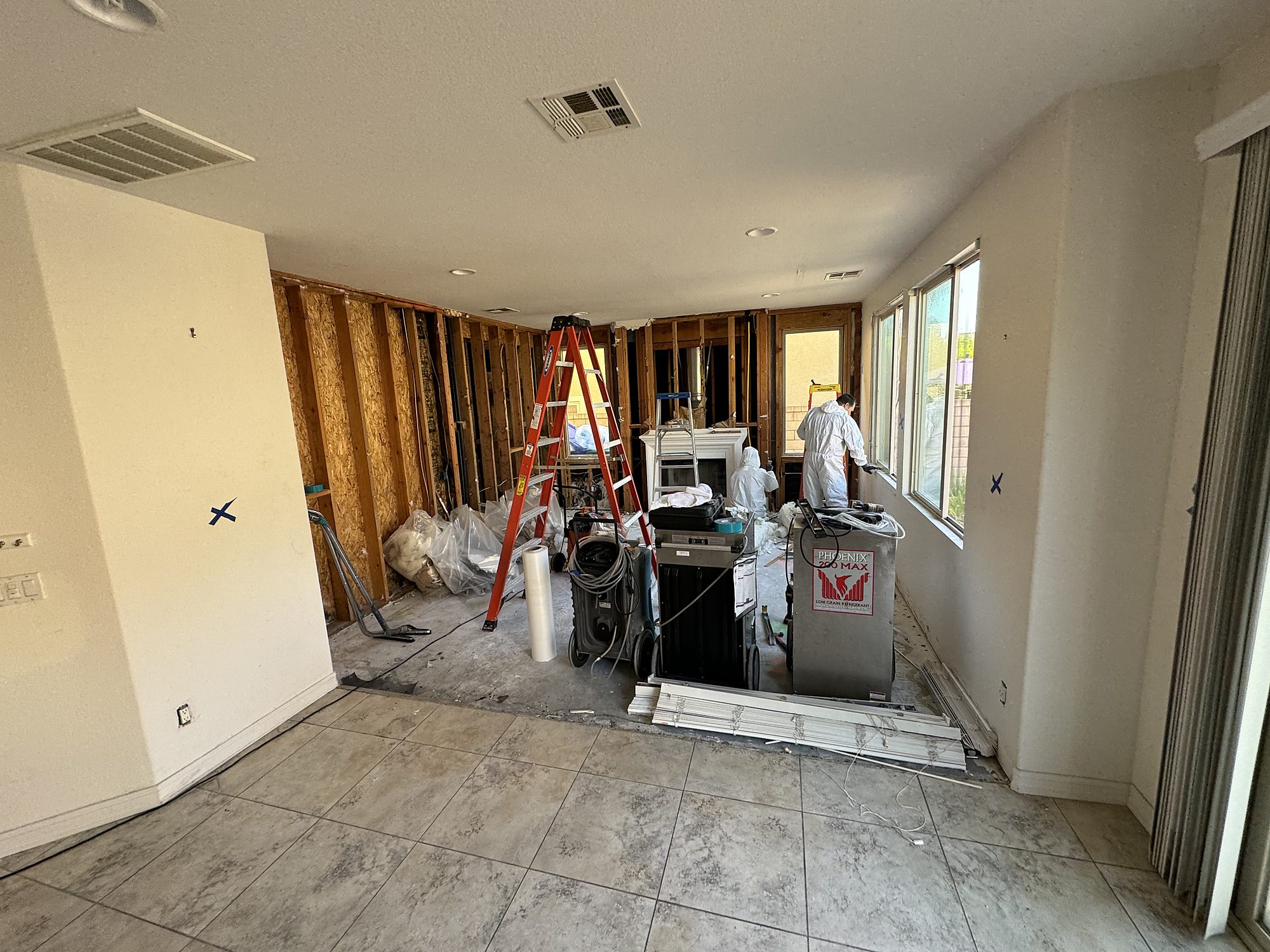 fire2-12-living-room-drying-equipment Living room opened to studs with dehumidification equipment running during water mitigation in San Diego