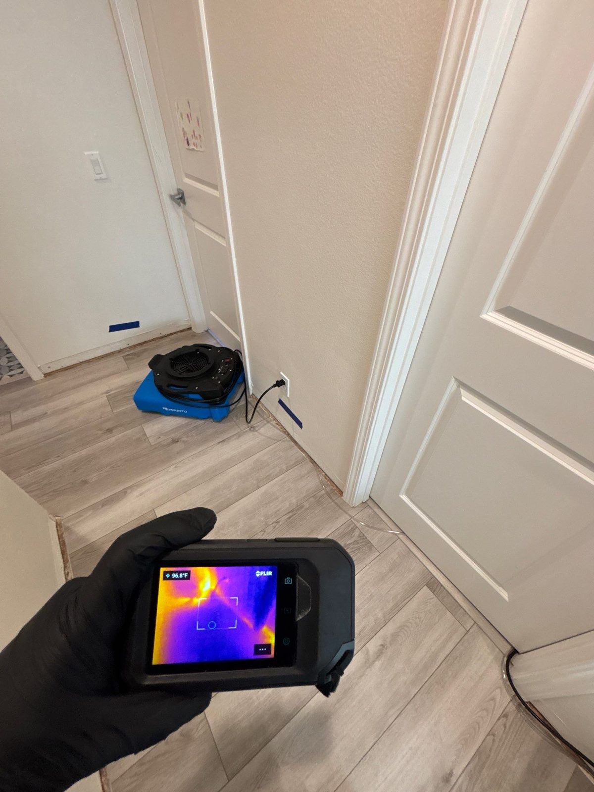 Thermal camera showing moisture behind a hallway wall during water damage restoration in a San Diego home